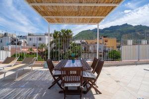 un patio avec une table et des chaises sur un toit dans l'établissement 2 Terraces and Pergola House in Ischia, à Ischia