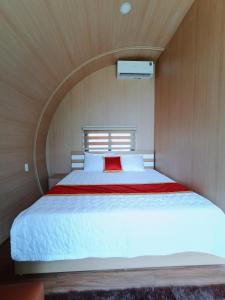 a bedroom with a large bed with a wooden wall at Sea Breezes-Gió Biển Bungalows in Ấp Long Sơn