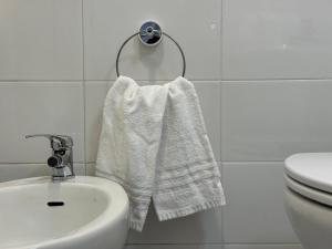 a bathroom with a white towel hanging next to a sink at Nido di mare in San Benedetto del Tronto