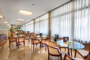 a restaurant with tables and chairs and windows at Atlantic Terme Natural Spa & Hotel in Abano Terme