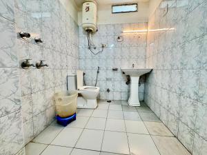 a bathroom with a toilet and a sink at Hotel Hampta pass view by silver land in Manāli