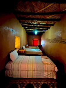 a bedroom with two beds in a room at Auberge Dar Lajdoud in Tafraoute Sidi Ali