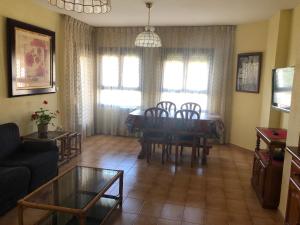 Una sala de estar con mesa de comedor y sillas. en Apartamentos MyM, en Jaca