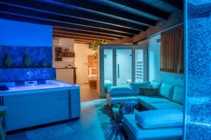 a living room with blue walls and a couch at Villa Agave Pool & Spa in Gaggi