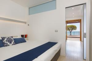a bedroom with a bed and a view of the ocean at Portopiccolo Apartments - Ulivo sul golfo in Portopiccolo Sistiana