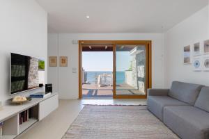 a living room with a couch and a view of the ocean at Portopiccolo Apartments - Ulivo sul golfo in Portopiccolo Sistiana