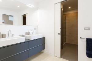 a bathroom with two sinks and a mirror at Portopiccolo Apartments - Ulivo sul golfo in Portopiccolo Sistiana +20 photos
