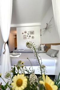 a bedroom with two beds and flowers in the foreground at Casa Mós in Lagos