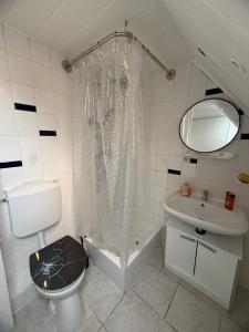 e bagno con tenda per la doccia, servizi igienici e lavandino. di Einzelzimmer mit Gemeinschaftsbad ohne Küche a Norimberga