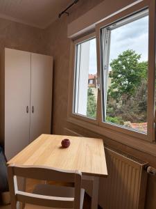 un tavolo da pranzo con due sedie e due finestre di Einzelzimmer mit Gemeinschaftsbad ohne Küche a Norimberga