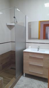 a bathroom with a sink and a shower with a mirror at Apartamento Playa La Calica in San Juan de los Terreros