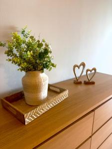 a vase with flowers and two hearts on a dresser at VV - The Marina Nest with Rooftop Pools in Gibraltar Airport +6 photos