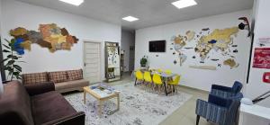 a living room with a couch and a table with yellow chairs at KASPI HOSTEl in Aktau