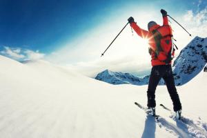 una persona con esquís en la nieve con los brazos en el aire en Apartamentos MyM, en Jaca