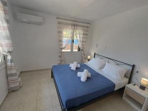 a bedroom with a blue bed with towels on it at Holiday Home Klimataria in Áyios Pétros