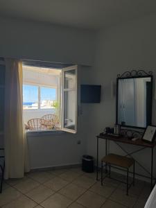 a room with a window and a table and a mirror at Esperance 2 in Ermoupoli