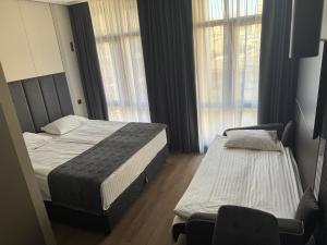 a hotel room with two beds and a chair at AVENUE RESIDENCE by AY North Avenue in Yerevan +64 photos