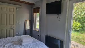 a bedroom with a bed and a television on a wall at Glebe House, Private entrance, free parking on drive, Self check in, Netflix in Ashford