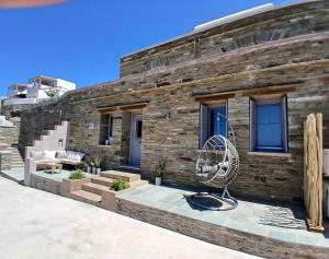 a brick house with a bench and a fan at Sails1 in Agia Eleousa