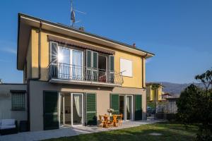 a house with a balcony and a table and chairs at Casa LUIS in Luino +31 photos