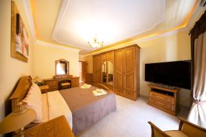 a bedroom with a bed and a flat screen tv at Seafront living with private Garage in St. Paul's Bay