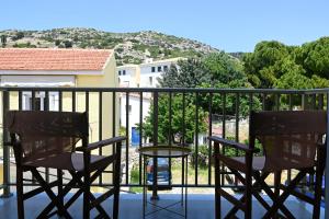 a patio with two chairs and a table on a balcony at Karamelaki in Pythagoreio