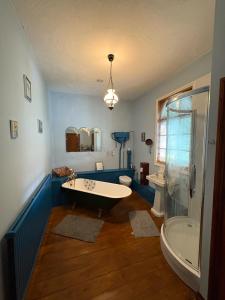 a bathroom with a tub and a toilet and a shower at Chapel House in Saint Cleer