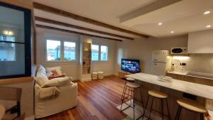 a living room with a kitchen and a living room with a counter at Apartamento Atlantico Pontus Veteris in Pontevedra