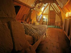 a bedroom with a bed and a hammock in it at Domaine de la Papeterie - 25 minutes Deauville Honfleur in Bonneville-la-Louvet