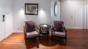 a dining room with two chairs and a table at MiraNamin Nest LIRYO and LANTANA Residence in Unique Historic Home - Garden, Rooftop, Private Kitchen in Manila +40 photos