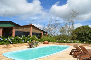 a swimming pool in front of a house at Refúgio do Rio Bonito in Bonito