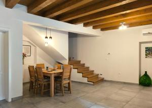 a dining room with a table and chairs and stairs at Old town stone house in Pula