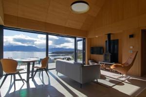 a living room with a couch and a table and chairs at 25a Camuscross in Isleornsay