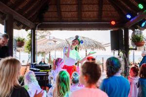 a girl in a colorful outfit holding an umbrella in a crowd at Hotel Tahití Playa & Suites 4Sup in Santa Susanna +68 photos