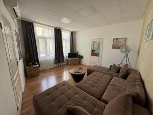 a living room with a large brown couch at habitat Heart of Ruse Apartment in Ruse