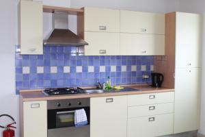 a kitchen with white cabinets and a stove top oven at Appartamento Bonita Vista in Colico +24 photos