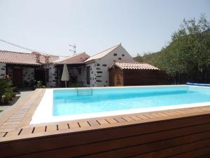 a large swimming pool in front of a house at La Casona Del Almendro in San Bartolomé