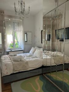 a bedroom with a large bed with a glass wall at Lux Beba Pancevo in Pančevo