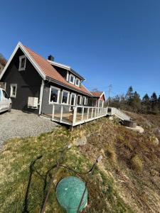 a house with a yard with a house at Landlig hytte med jacuzzi in Lyngdal