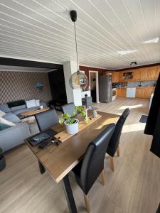 a dining room with a table and a living room at Landlig hytte med jacuzzi in Lyngdal