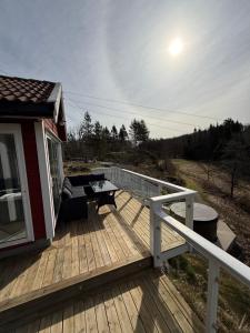 a wooden deck with a picnic table on a house at Landlig hytte med jacuzzi in Lyngdal