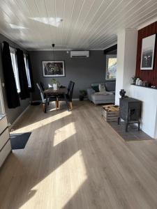 a living room with a table and a couch at Landlig hytte med jacuzzi in Lyngdal