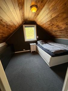 a bedroom with a bed and a window in a room at Landlig hytte med jacuzzi in Lyngdal