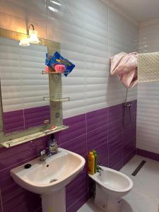 a bathroom with a sink and a mirror and a toilet at Spacieux Appartement Selouane Nador in Selouane +12 photos