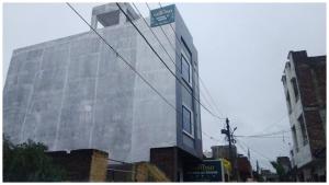 a tall glass building with a street sign on it at Near Shri Mahakaleshwar Jyotirlinga Temple HOTEL G-A-R-I-M-A ! UJJAIN - Providing Air Conditioned Rooms With Free Wi-fi Facility And Free Parking Available in Ujjain