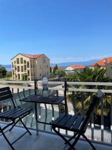 a table and two chairs on a balcony at Casa Estancia Apartment in Njivice