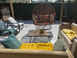 埃斯特城Ivy House Apart Hotel的天井上配有沙发和椅子