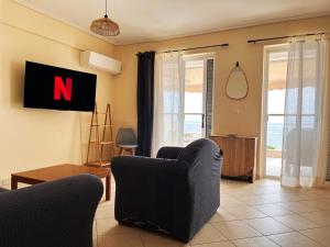 a living room with a n sign on the wall at Sur La Mer - SeaSide Apartments in Mavrovouni