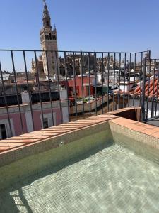 a swimming pool on top of a building with a clock tower at Casa del Gobernador by Época Suites in Seville