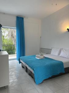 a bedroom with a bed and a large window at Sophies Olive haven in Possidi
